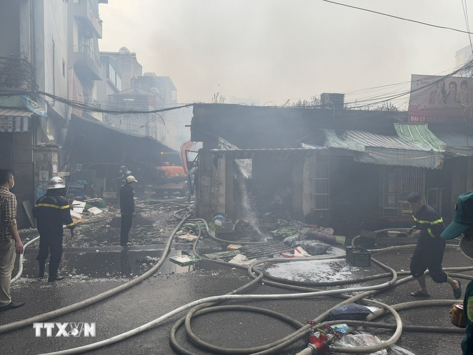 Các tổ công tác tiếp tục triển khai dập tàn và làm mát các cấu kiện để phòng ngừa cháy bùng phát trở lại. (Ảnh: Quốc Lũy/TTXVN)