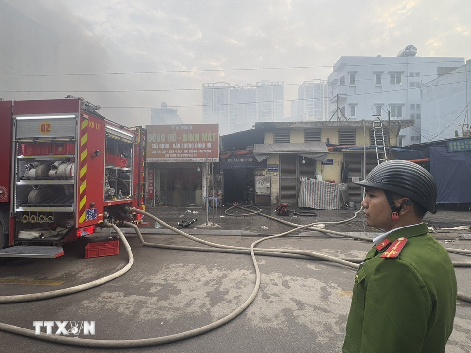 Lực lượng chức năng bảo vệ hiện trường vụ cháy. (Ảnh: Quốc Lũy/TTXVN)