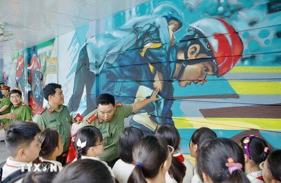 Học sinh tham quan bức bích họa "Lá chắn bình yên" tại Trung tâm Giáo dục cộng đồng về Phòng cháy chữa cháy và cứu nạn cứu hộ, Công an Thành phố Hồ Chí Minh (4/10/2024). (Ảnh: Thanh Vũ/TTXVN)