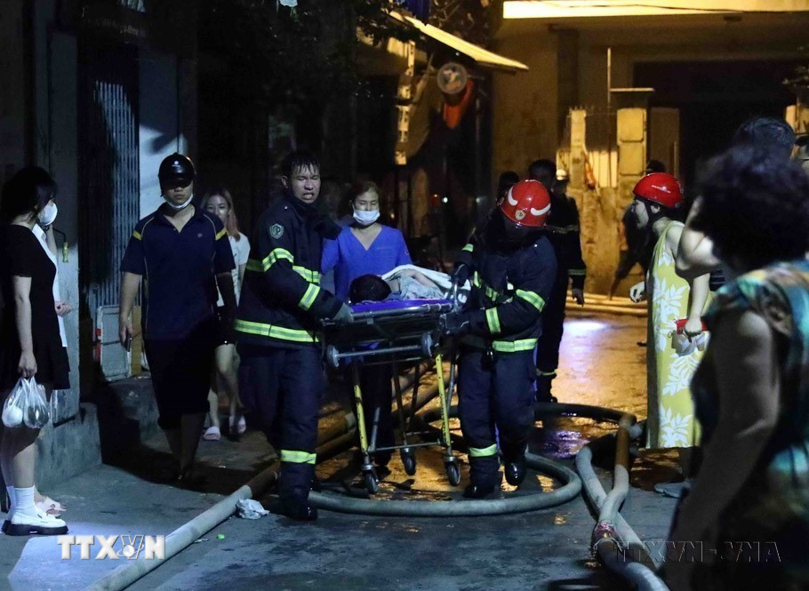 Lực lượng cảnh sát Phòng cháy chữa cháy đưa nạn nhân ra khỏi hiện trường trong vụ cháy chung cư mini tại ngõ 29/70, phố Khương Hạ, quận Thanh Xuân (Hà Nội), đêm 12/9/2023. (Ảnh: Phạm Kiên/TTXVN)