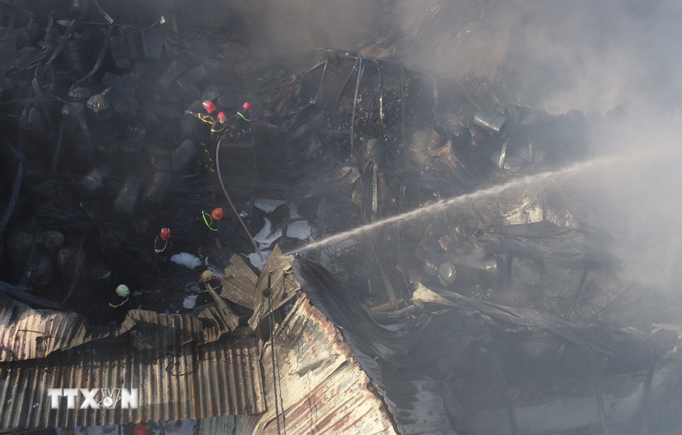 Lực lượng cảnh sát Phòng cháy chữa cháy phun nước ngăn chặn lửa bùng phát trở lại trong vụ cháy kho hàng tại số nhà 27 và 29 đường Hoàng Văn Thái, phường Hòa Minh, quận Liên Chiểu, thành phố Đà Nẵng. (Ảnh: Quốc Dũng/TTXVN)