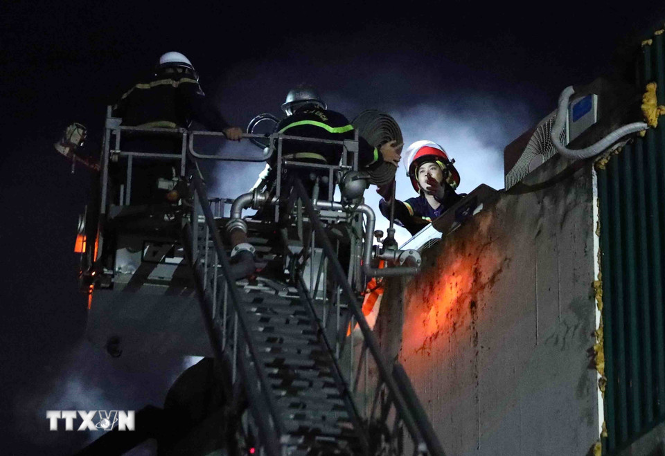 Cảnh sát Phòng cháy chữa cháy sử dụng thang cứu hộ xử lý đám cháy tại địa chỉ 231 Quan Hoa, phường Quan Hoa, quận Cầu Giấy (Hà Nội), tối 1/8/2022. (Ảnh: Phạm Kiên/TTXVN)