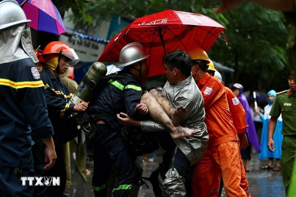 Lực lượng cứu hỏa đưa nạn nhân cuối cùng ra khỏi đám cháy tòa nhà 5 tầng ở số 8, ngõ 12, phố Núi Trúc, quận Ba Đình, Hà Nội. (Ảnh: Dương Giang/TTXVN)