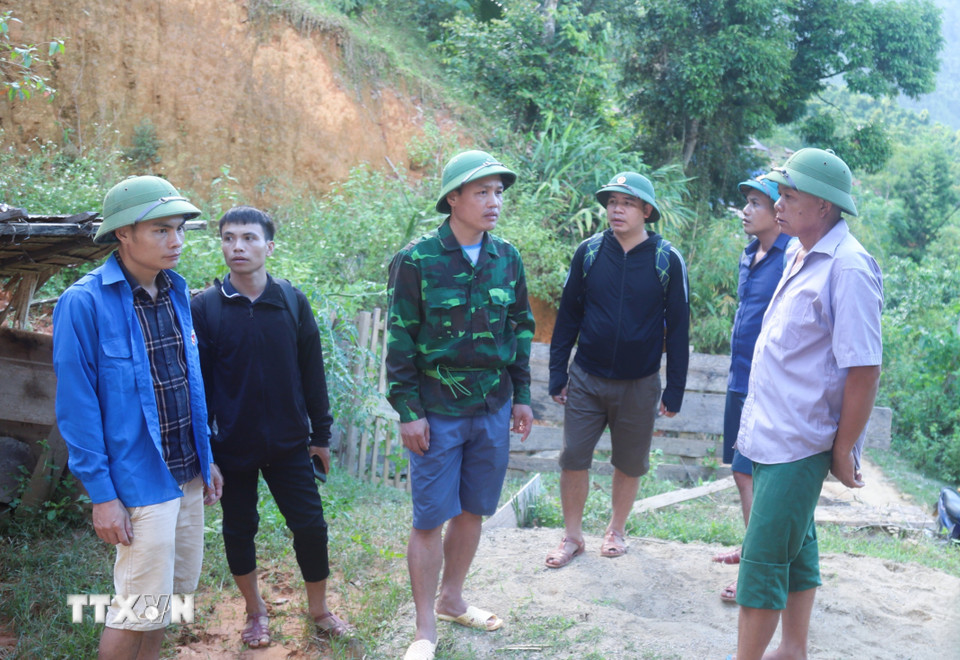 Ông Lương Tuấn Dũng, Phó Chủ tịch Ủy ban Nhân dân xã Nga My (giữa) hỏi thăm, động viên hộ dân có nhà bị sạt lở tại bản Na Ngân. (Ảnh: Xuân Tiến/TTXVN)