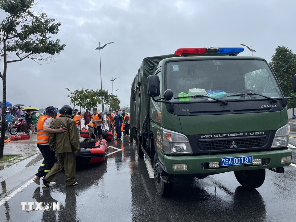 Lực lượng Cảnh sát phòng cháy chữa cháy Công an tỉnh Quảng Ngãi chuẩn bị phương tiện đưa người dân giữa dòng sông Trà Khúc vào bờ. (Ảnh: TTXVN)