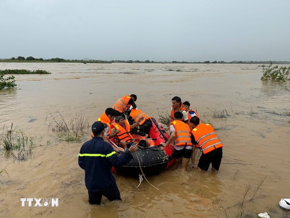 Lực lượng Cảnh sát phòng cháy chữa cháy Công an tỉnh Quảng Ngãi cưỡng chế đưa người dân giữa dòng sông Trà Khúc vào bờ. (Ảnh: TTXVN)