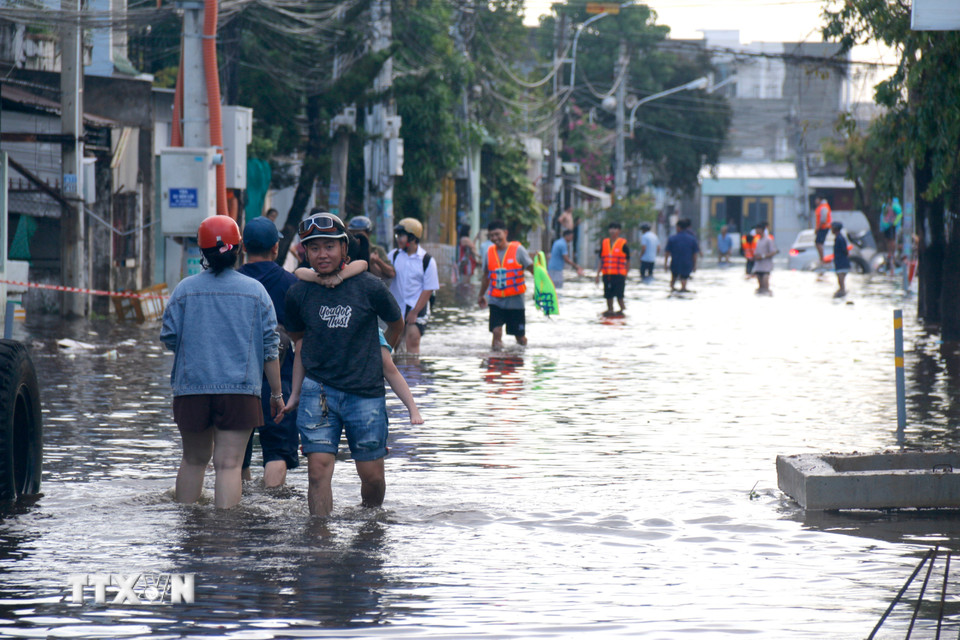 Người dân những khu vực ngập sâu di chuyển đến nơi ở khác. (Ảnh: Nguyễn Thanh/TTXVN)