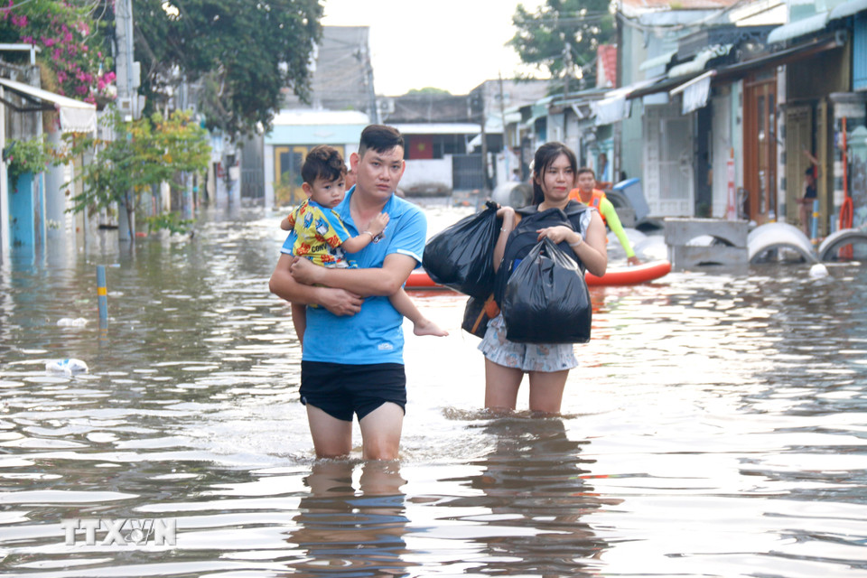 Người dân những khu vực ngập sâu di chuyển đến nơi ở khác. (Ảnh: Nguyễn Thanh/TTXVN)