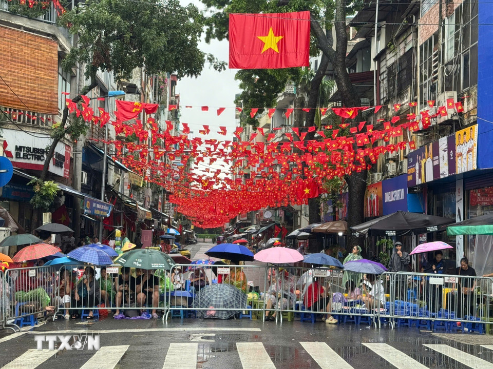 Bất chấp cơn mưa lớn, hàng nghìn người dân vẫn đổ về các tuyến phố chờ đợi chào đón các khối diễu binh sơ duyệt cho Đại lễ 80 năm Quốc khánh. (Ảnh: Minh Quyết/TTXVN)