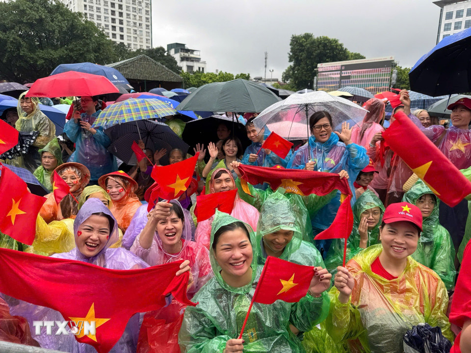 Tình yêu và niềm tự hào lớn hơn cơn mưa. Khoảnh khắc người dân Thủ đô không quản ngại thời tiết, kiên nhẫn chờ đợi và cổ vũ cho các lực lượng vũ trang. (Ảnh: Minh Quyết/TTXVN)