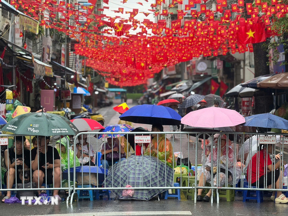 Tình quân dân nồng ấm xua tan đi cái lạnh của cơn mưa. Sự cổ vũ nhiệt thành của nhân dân là nguồn động viên, tiếp thêm sức mạnh tinh thần to lớn cho các chiến sĩ. (Ảnh: Minh Quyết/TTXVN)