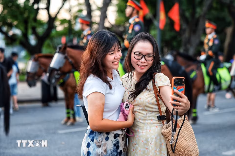 Người dân vui vẻ chụp ảnh lưu niệm bên cạnh đoàn kỵ binh. (Ảnh: Phạm Tuấn Anh/TTXVN)