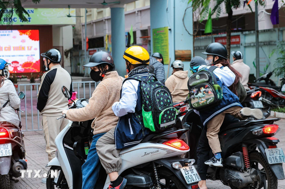 Học sinh được phụ huynh đưa đến trường trong ngày đầu tiên đi học năm 2026. (Ảnh: Hoàng Hiếu/TTXVN)
