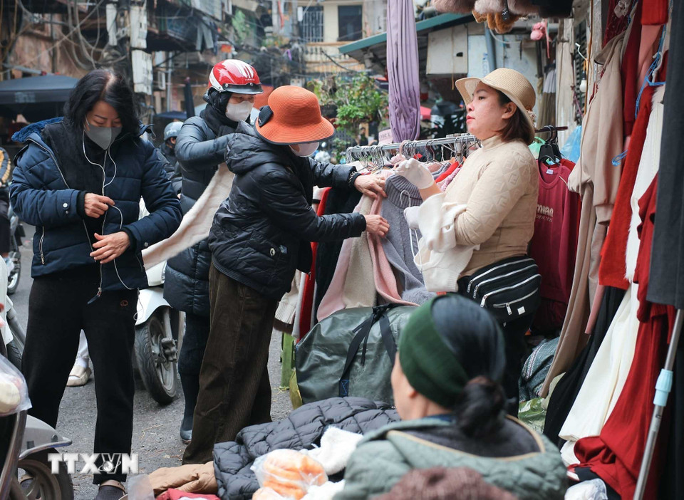 Tại các chợ dân sinh, nhiều người dân đã đến từ sớm mua đồ ấm khi thời tiết trở lạnh. (Ảnh: Hoàng Hiếu/TTXVN)