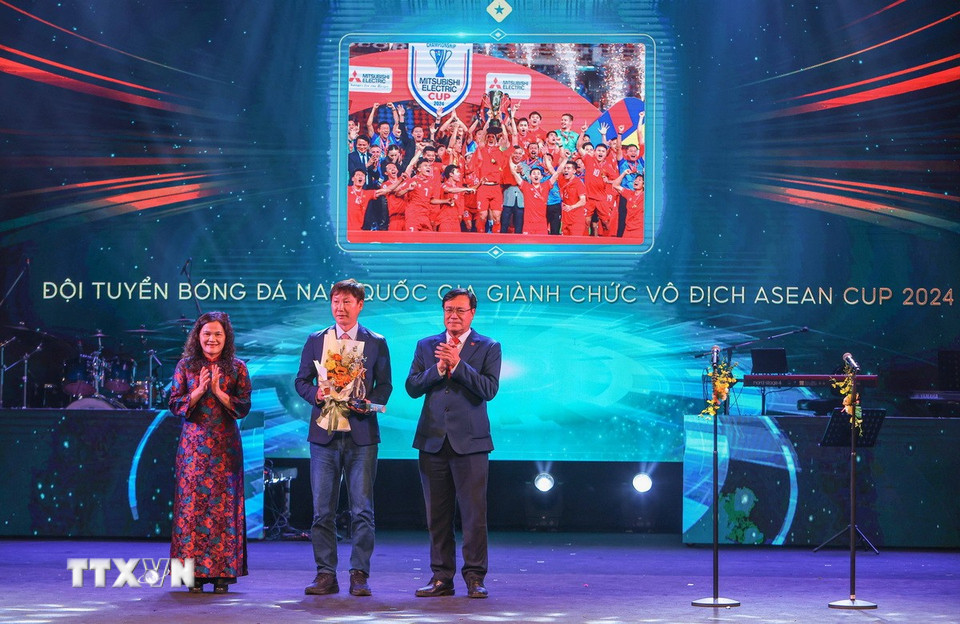 Phó Tổng Giám đốc TTXVN Nguyễn Thị Sự và Cục trưởng Cục thể thao Đặng Hà Việt trao “Chiến tích thể thao của năm” cho huấn luyện viên Kim Sang Sik - đại diện đội tuyển bóng đá nam Việt Nam. (Ảnh: Hoàng Hiếu/TTXVN)
