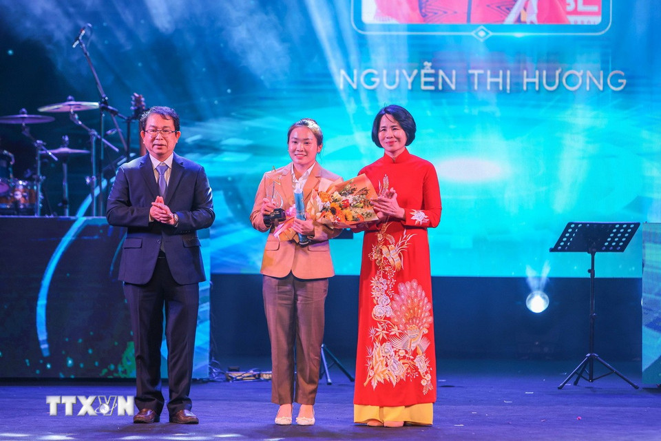 Phó Tổng giám đốc TTXVN Nguyễn Tuấn Hùng và Phó Cục trưởng Cục thể thao Lê Thị Hoàng Yến trao giải “Gương mặt trẻ thể thao của năm” cho vận động viên đua thuyền Canoeing Nguyễn Thị Hương. (Ảnh: Hoàng Hiếu/TTXVN)