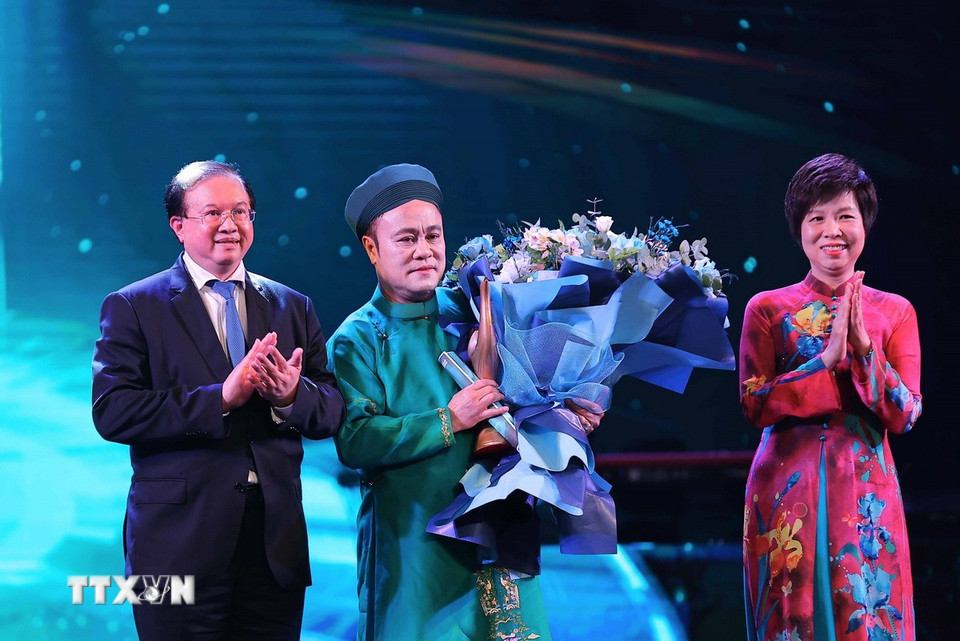 Thứ trưởng Bộ Văn hóa, Thể thao và Du lịch Tạ Quang Đông và Tổng Giám đốc TTXVN Vũ Việt Trang trao giải "Nghệ sỹ truyền cảm hứng" cho nghệ sỹ Chu Bảo Quế. (Ảnh: Phạm Tuấn Anh/TTXVN)
