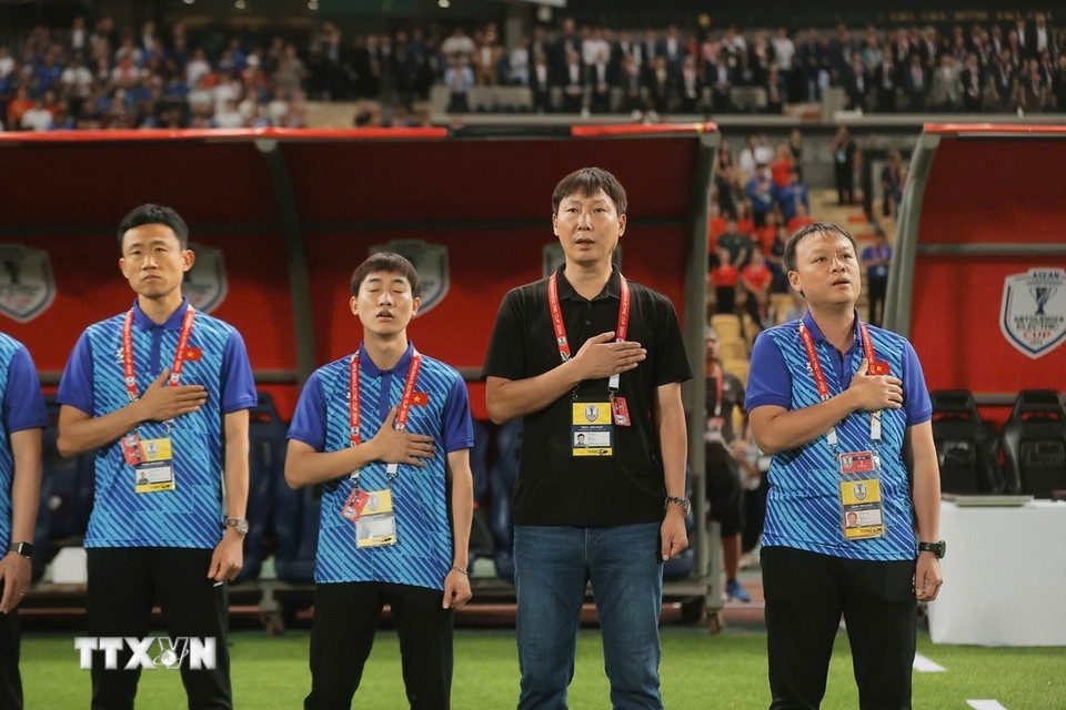 HLV Kim Sang-sik và Ban huấn luyện đội tuyển Việt Nam thực hiện nghi thức chào cờ. (Ảnh: Minh Quyết/TTXVN)