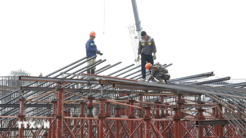 Cán bộ, kỹ sư, công nhân hăng say làm việc tại công trình xây dựng cầu qua sông Tràng An, phường Hoa Lư ngày đầu Năm mới. (Ảnh: Đức Phương/TTXVN)
