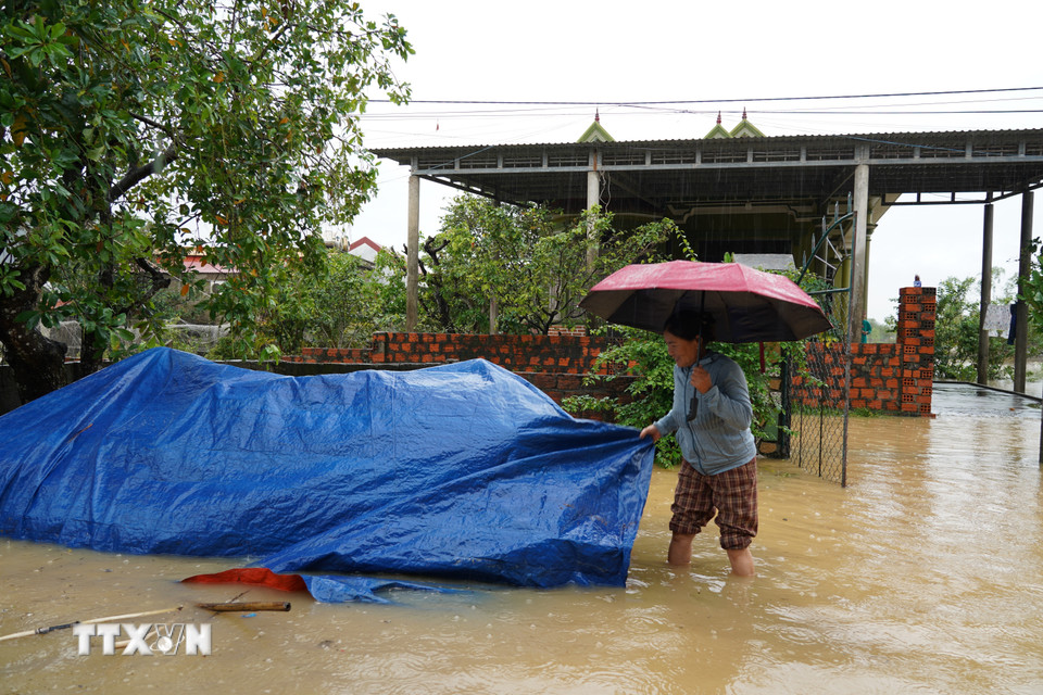 Người dân đang tích cực dọn dẹp, kê cao đồ đạc để bảo vệ tài sản trong cơn mưa lũ. (Ảnh: Thanh Thủy/TTXVN)