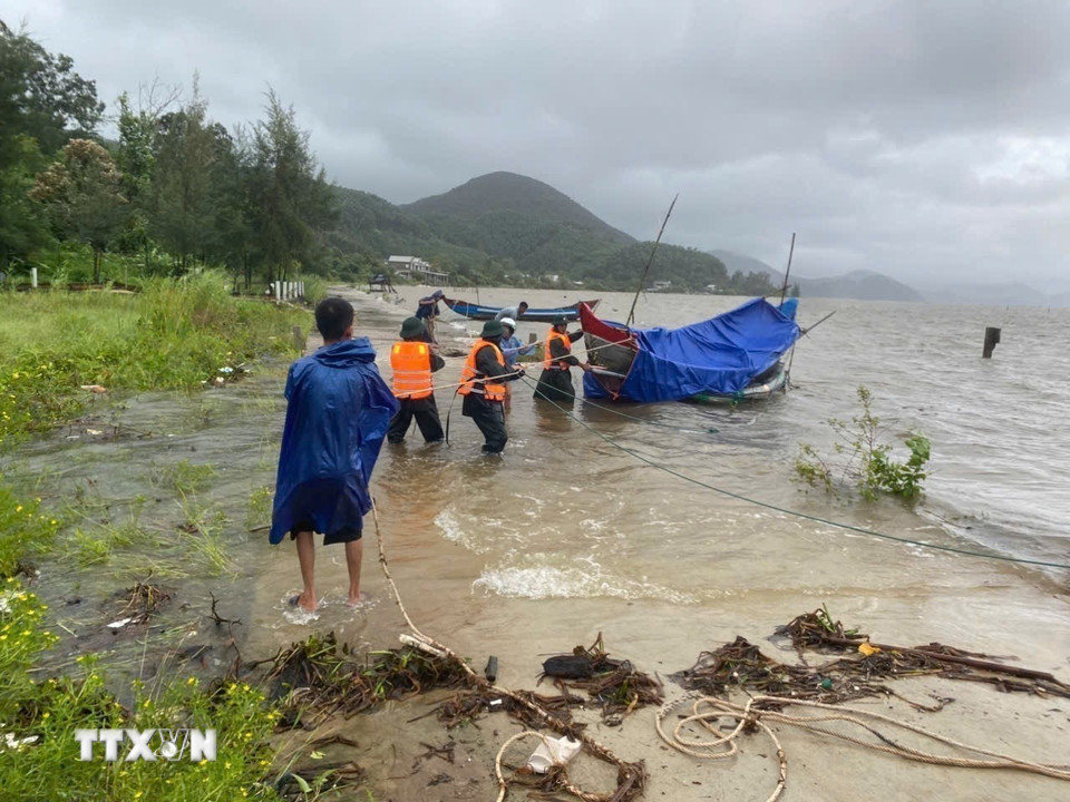 Giúp ngư dân ứng phó bão số 10. (Ảnh: Mai Trang/TTXVN)