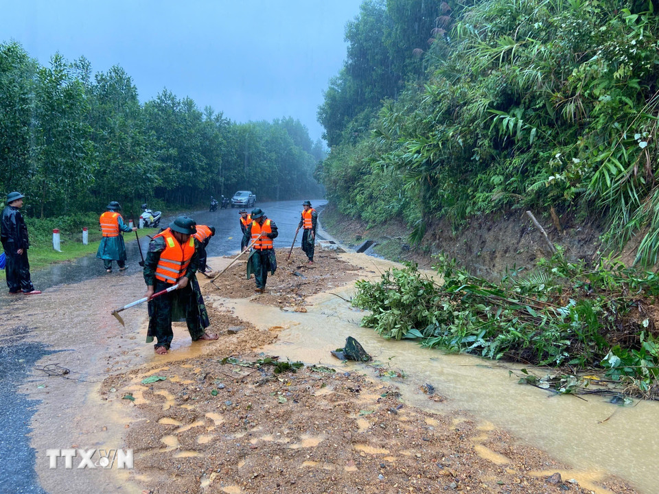 Bộ đội biên phòng thành phố Huế đào xúc đất đá, san gạt mặt đường bị sạt lở đất tại đèo Pê Kê, xã A Lưới 1. (Ảnh: Mai Trang/TTXVN)