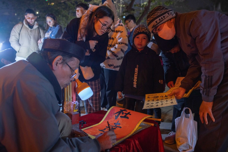 Người dân xin chữ tại khu vực đền Bà Kiệu trong thời khắc đầu tiên của năm mới Ất Tỵ. (Ảnh: Hoàng Hiếu/TTXVN)