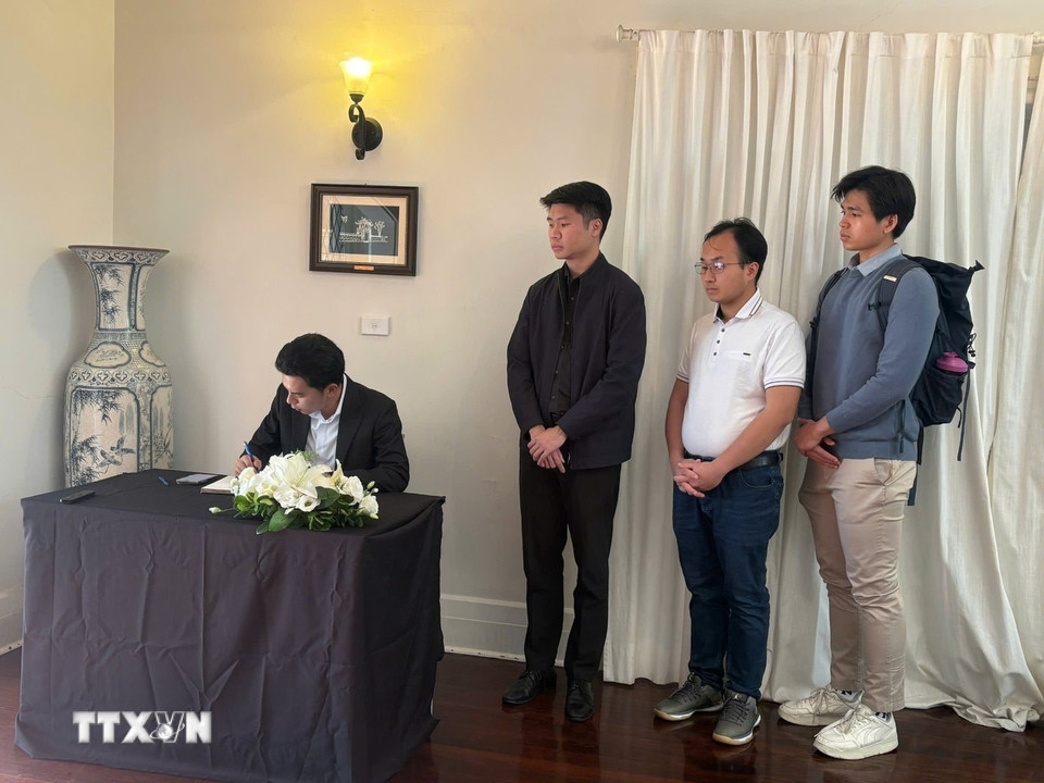 Đại diện Hội sinh viên Việt Nam tại Australia ghi sổ tang tưởng nhớ nguyên Chủ tịch nước Trần Đức Lương. (Ảnh: Văn Linh/TTXVN)