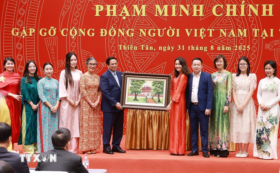 Thủ tướng Phạm Minh Chính tặng quà cộng đồng người Việt Nam tại Trung Quốc. (Ảnh: Dương Giang/TTXVN)