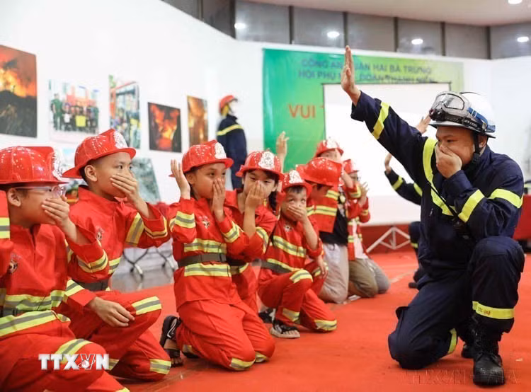 Thiếu nhi thủ đô trải nghiệm làm lính cứu hỏa, thực hiện kỹ năng di chuyển thoát ra khỏi đám khói tại "Ngày hội Thế giới tuổi thơ" do Bộ Văn hóa, Thể thao và Du lịch tổ chức (1/6/2023). (Ảnh: Thanh Tùng/TTXVN)