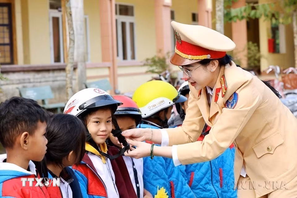 Hội Phụ nữ Phòng Cảnh sát giao thông Công an tỉnh Quảng Trị tặng mũ bảo hiểm cho học sinh trường Phổ thông Dân tộc bán trú Tiểu học Vĩnh Hà (xã Bến Quan) tại Ngày hội thiếu nhi với chủ đề “Sắc xuân tuổi thơ - Hương vị Tết Việt”. (Ảnh: TTXVN)