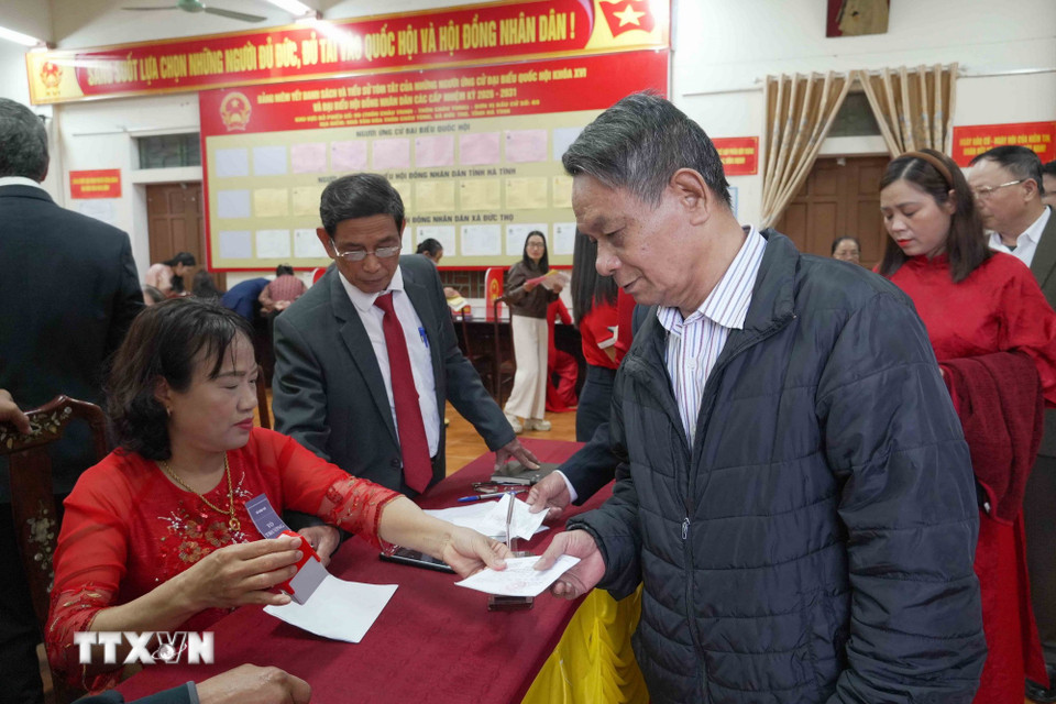 Cử tri tại đơn vị bầu cử số 3, khu vực bỏ phiếu số 9, thôn Châu Tùng (xã Đức Thọ) đóng dấu vào phiếu cử tri sau khi hoàn thành bầu cử. (Ảnh: Hữu Quyết/TTXVN)