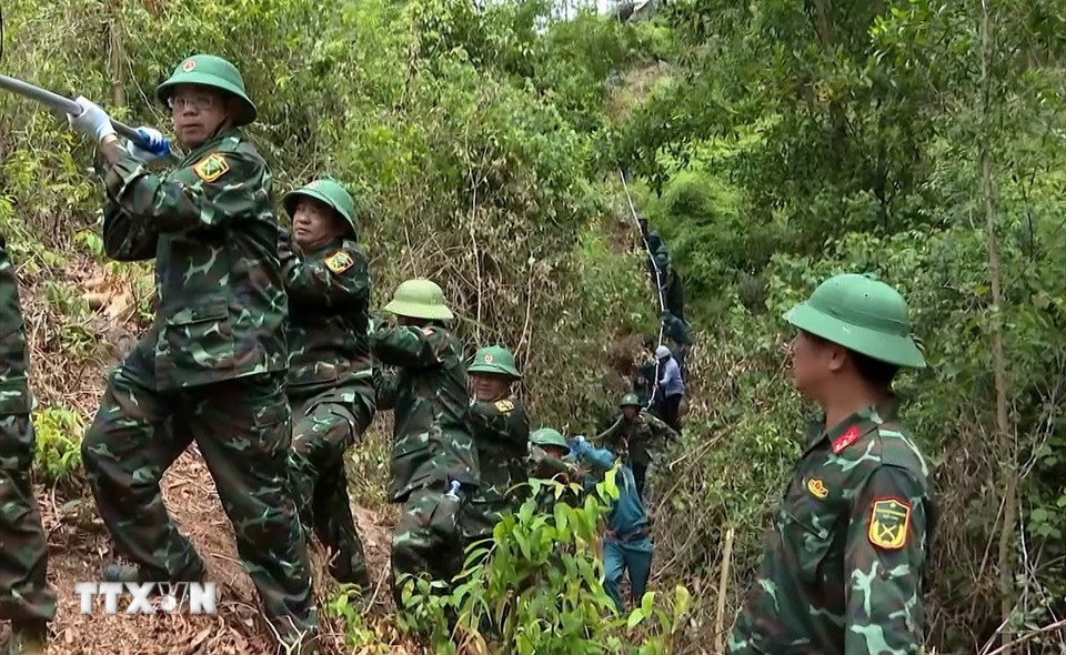 Lực lượng vũ trang Nghệ An huy động hơn 600 lượt cán bộ, chiến sỹ hỗ trợ phát quang, giải phóng mặt bằng, tạo hành lang an toàn lưới điện, vận chuyển cuộn cáp điện, vật liệu, rải kéo dây, san lấp hoàn trả mặt bằng phục vụ dự án 500 kV mạch 3. (Ảnh: Văn Tý/TTXVN)