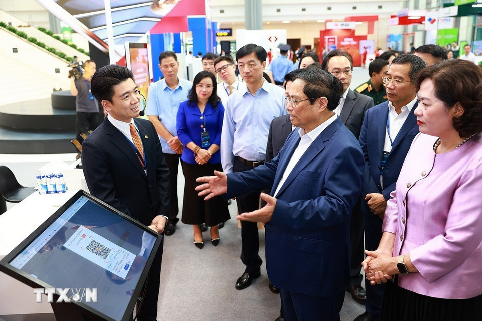 Thủ tướng Phạm Minh Chính tham quan trưng bày về ứng dụng chuyển đổi số trong lĩnh vực ngân hàng. (Ảnh: Dương Giang/TTXVN)