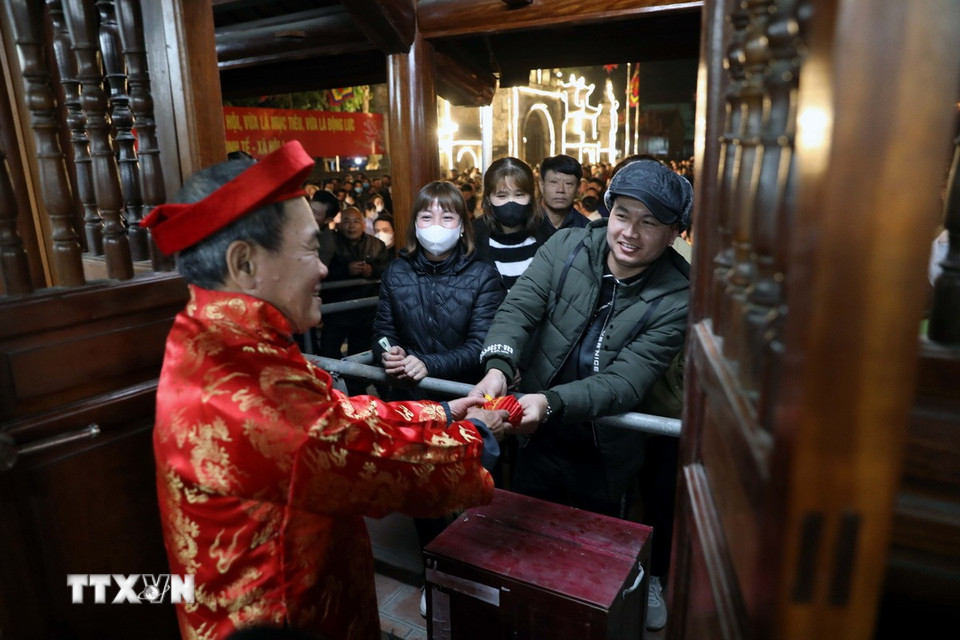 Các bô lão địa phương phát lương cho người dân và du khách. (Ảnh: Đại Nghĩa/TTXVN)