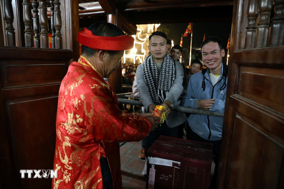 Các bô lão địa phương phát lương cho người dân và du khách. (Ảnh: Đại Nghĩa/TTXVN)