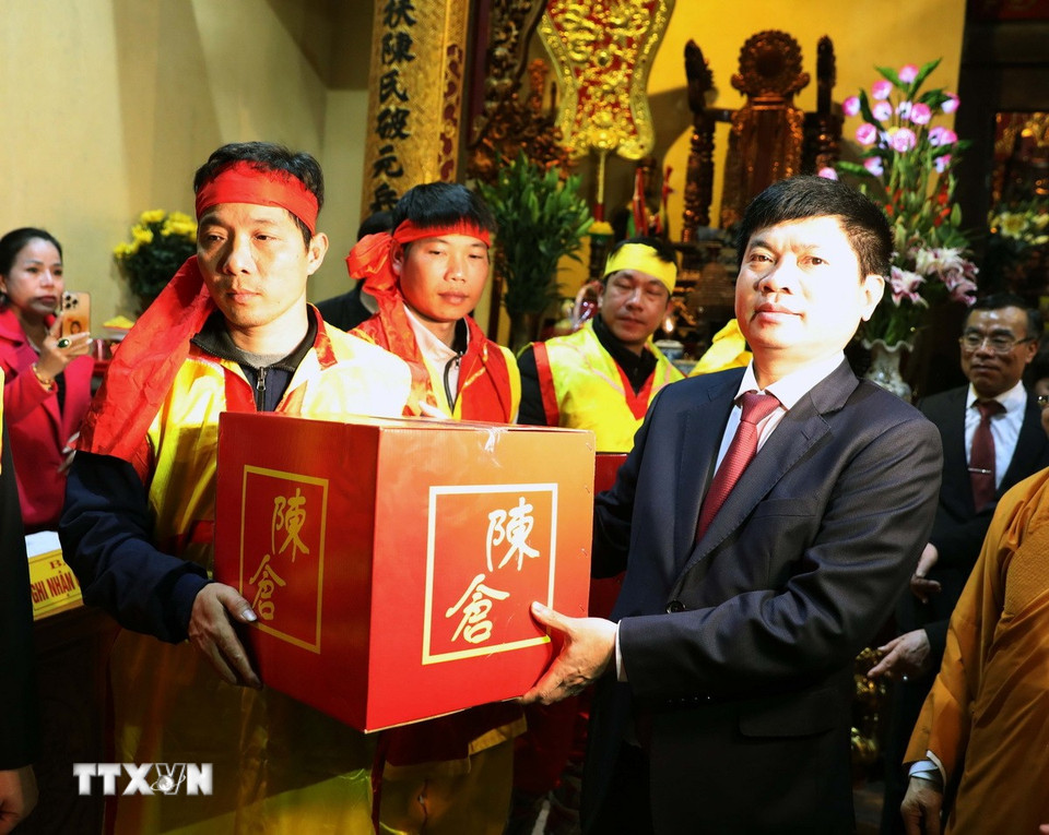 Đúng 23 giờ ngày 11/2, Ban tổ chức tiến hành vận chuyển lương từ cung cấm đền Trần Thương để ra các điểm phát cho nhân dân. (Ảnh: Đại Nghĩa/TTXVN)