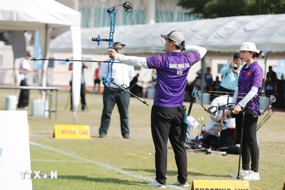 Hai vận động viên Đặng Công Đức và Lê Phạm Vân Anh thi đấu nội dung cung 3 dây đôi nam nữ hỗn hợp. (Ảnh: Minh Quyết/TTXVN)