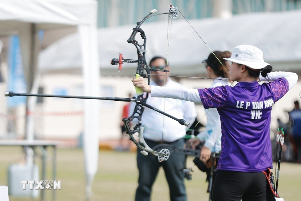 Vận động viên Lê Phạm Vân Anh thi đấu nội dung cung 3 dây đôi nam nữ hỗn hợp. (Ảnh: Minh Quyết/TTXVN)