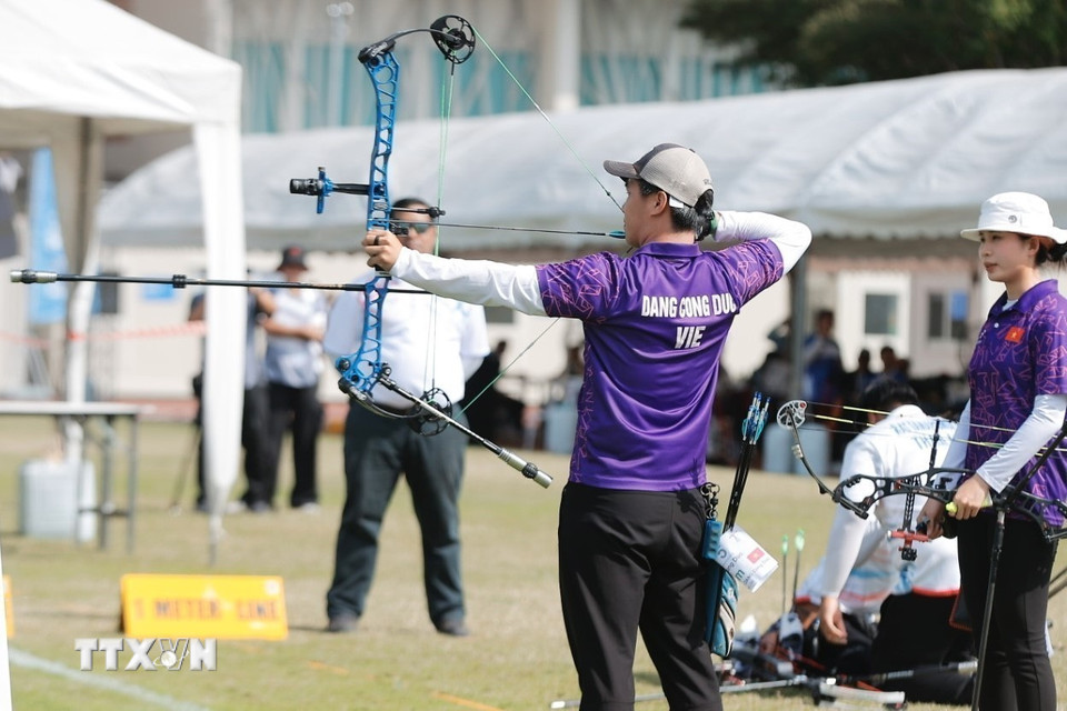 Hai vận động viên Đặng Công Đức và Lê Phạm Vân Anh thi đấu nội dung cung 3 dây đôi nam nữ hỗn hợp. (Ảnh: Minh Quyết/TTXVN)