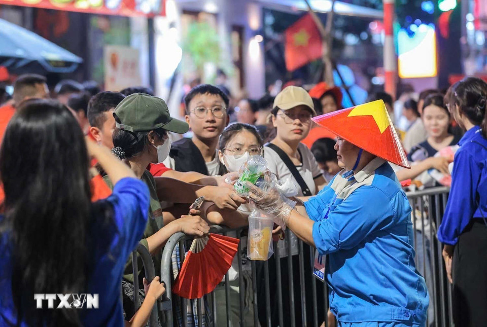 Những công nhân vệ sinh môi trường cần mẫn xuyên đêm hỗ trợ đảm bảo vệ sinh môi trường trên các tuyến phố nơi nhân dân tập trung chờ xem diễu binh, diễu hành. (Ảnh: Hoàng Hiếu/TTXVN)