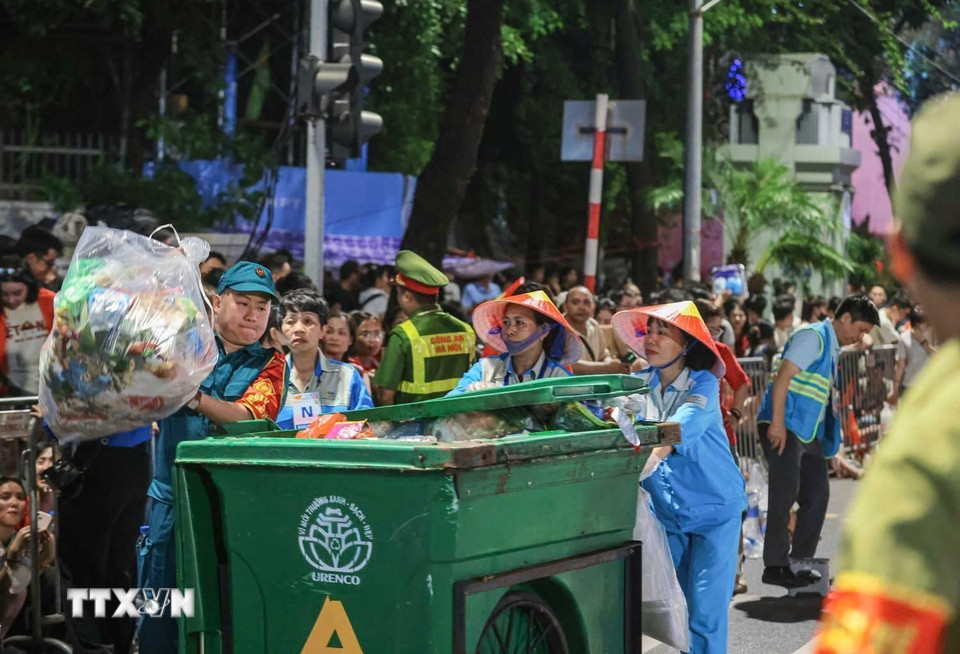 Những công nhân vệ sinh môi trường cần mẫn xuyên đêm hỗ trợ đảm bảo vệ sinh môi trường trên các tuyến phố nơi nhân dân tập trung chờ xem diễu binh, diễu hành. (Ảnh: Hoàng Hiếu/TTXVN)