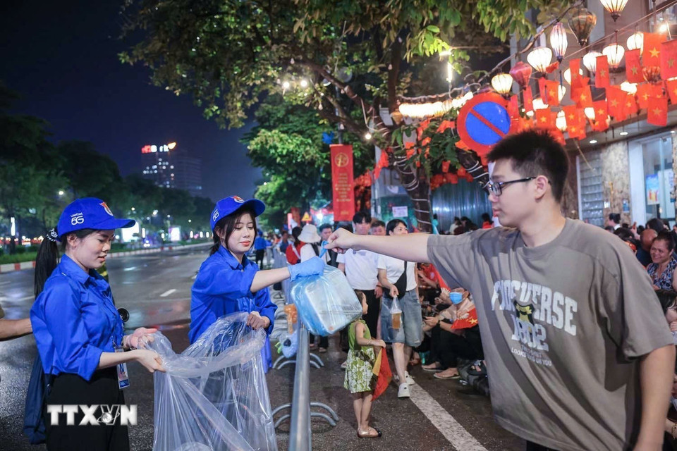 Lực lượng thanh niên tình nguyện hỗ trợ người dân dọn dẹp vệ sinh môi trường trên các tuyến phố. (Ảnh: Hoàng Hiếu/TTXVN)