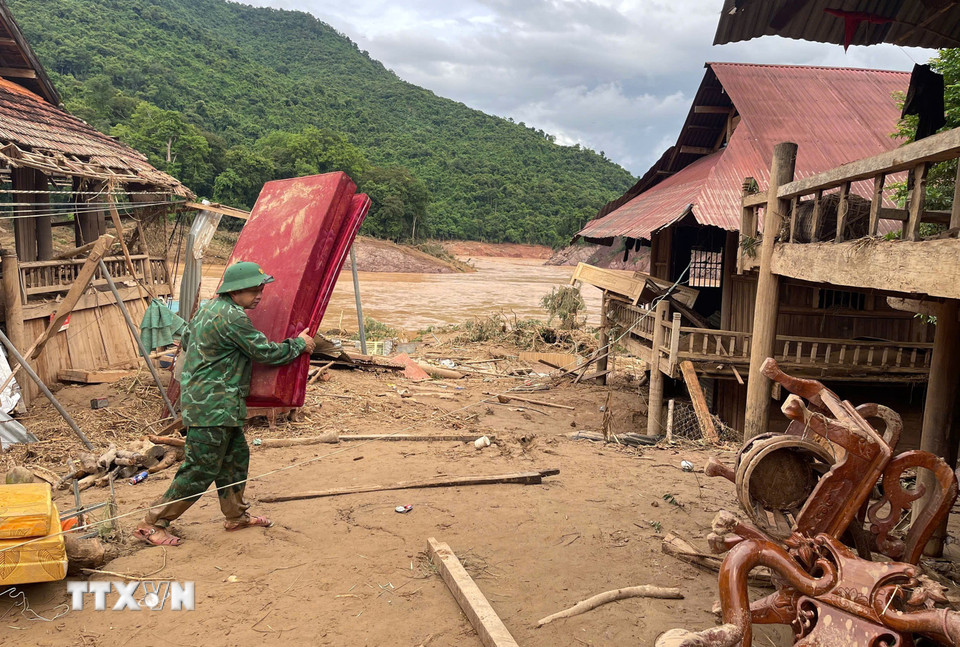 Chiến sỹ Đồn biên phòng Mỹ Lý giúp người dân địa phương khắc phục hậu quả mưa lũ. (Ảnh: TTXVN phát)