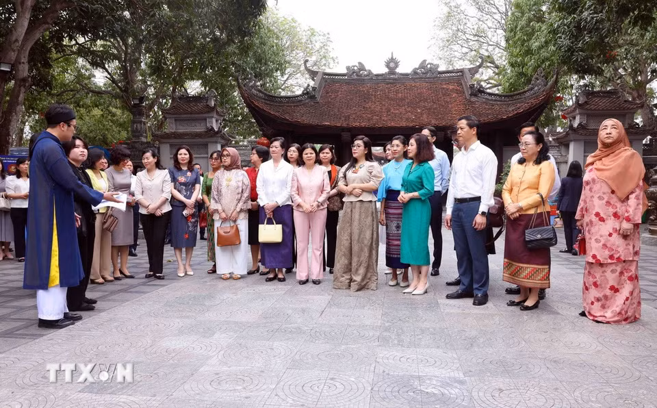 Bà Lê Thị Bích Trân, Phu nhân Thủ tướng Chính phủ Phạm Minh Chính và Nhóm Phụ nữ cộng đồng ASEAN tại Hà Nội nghe giới thiệu về lịch sử Đền Đô. (Ảnh: Phạm Kiên/TTXVN)