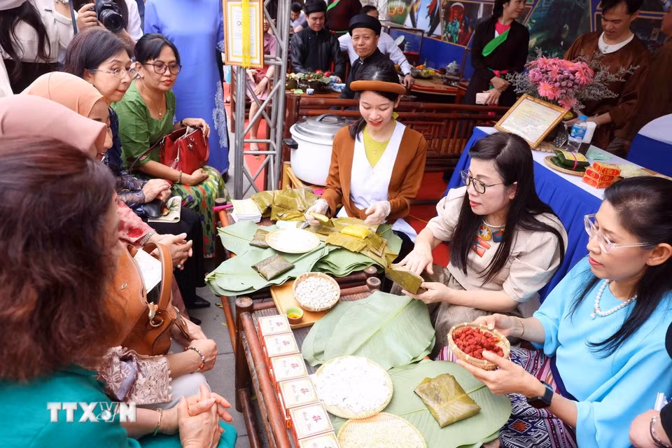 Bà Lê Thị Bích Trân, Phu nhân Thủ tướng Chính phủ Phạm Minh Chính và nhóm Phụ nữ cộng đồng ASEAN tại Hà Nội trải nghiệm làm bánh phu thê. (Ảnh: Phạm Kiên/TTXVN)