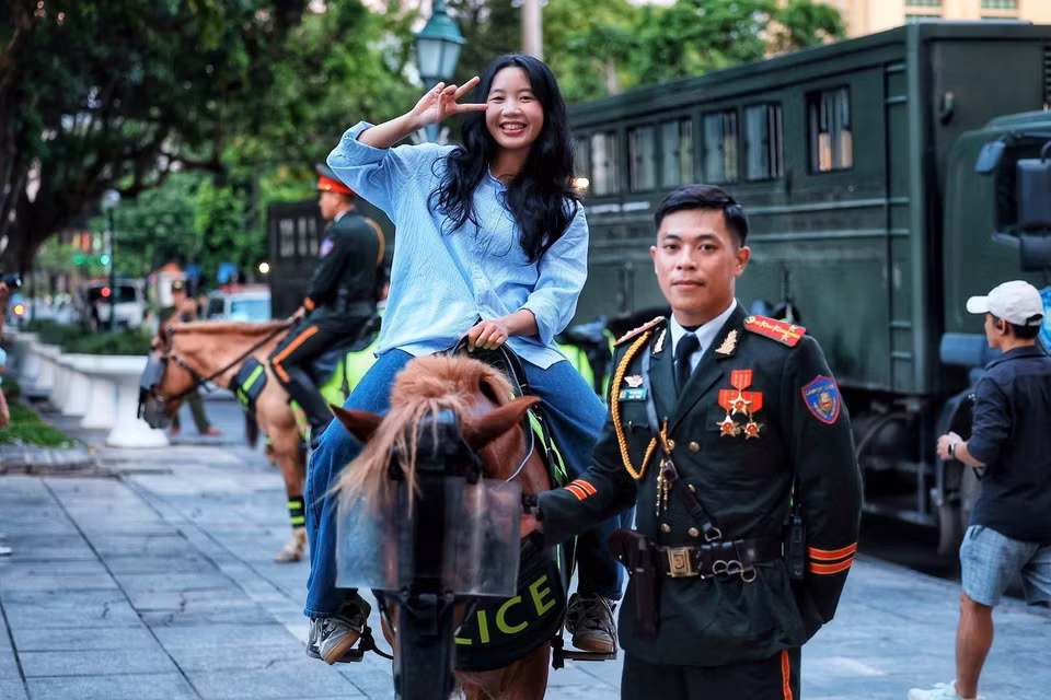 Các bạn trẻ hào hứng trải nghiệm cưỡi ngựa và chụp ảnh lưu niệm cùng với kỵ binh. (Ảnh: Phạm Tuấn Anh/TTXVN)