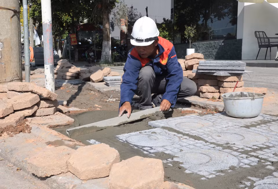 Công nhân thi công công trình giao thông phải làm việc dưới nền nhiệt cao, quần áo ướt đẫm mồ hôi giữa trưa nắng. (Ảnh: Tạ Toàn/TTXVN)