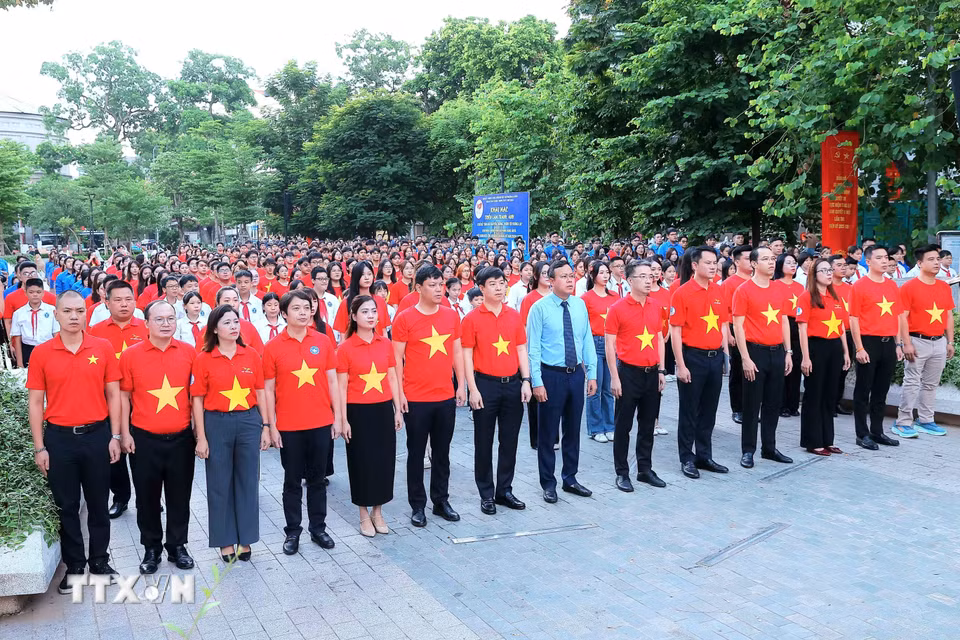 Các đại biểu và thanh niên, đoàn viên thực hiện nghi lễ chào cờ. (Ảnh: An Đăng/TTXVN)