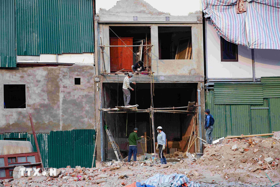 Công nhân, thợ xây hối hả thi công cải tạo mặt tiền mới cho các ngôi nhà. (Ảnh: Vũ Quang/TTXVN)